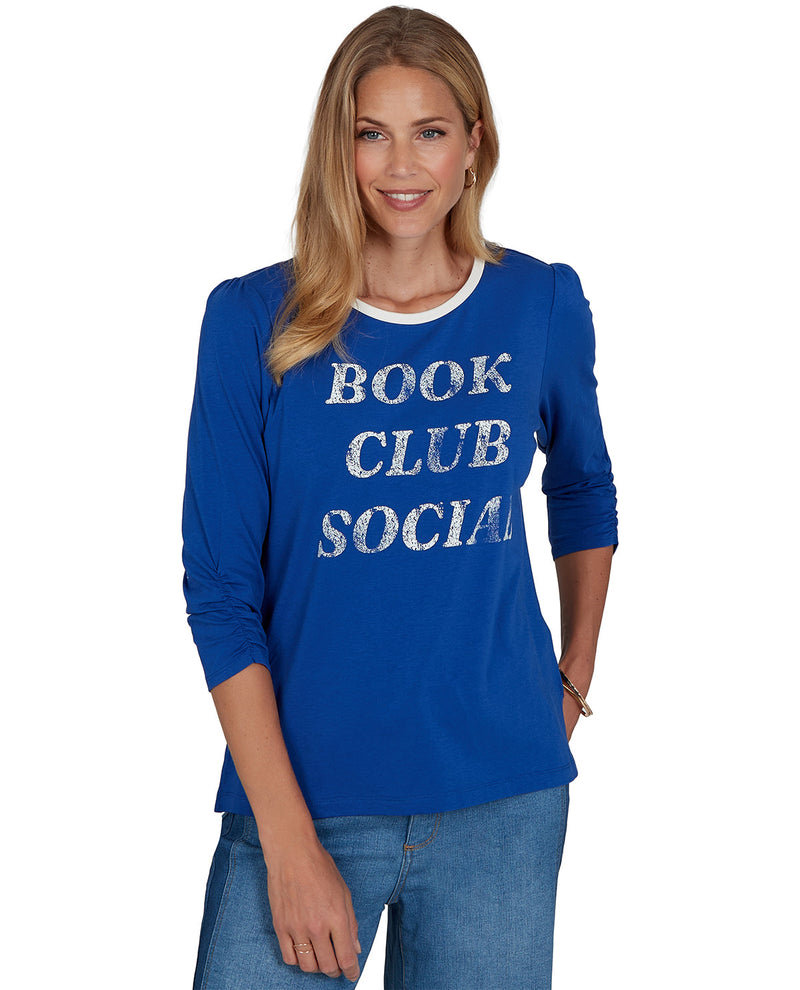 Woman wearing a petite blue shirt with 'BOOK CLUB SOCIAL' text on a white background