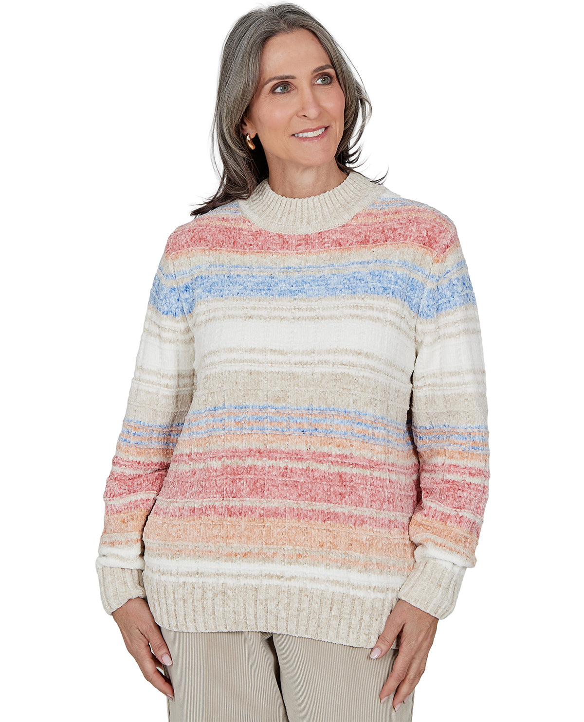 A woman wearing a knit sweater with horizontal stripes in cream, beige, pink, and light blue, paired with beige pants, against a plain white background.