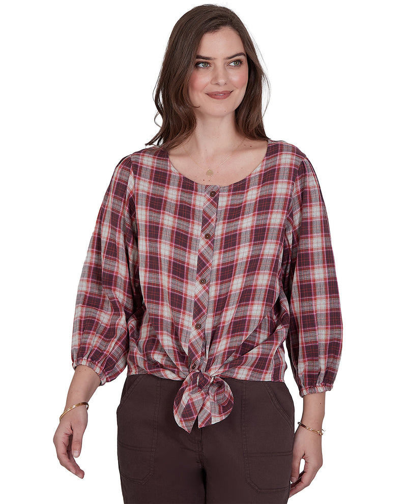 Woman wearing a plaid shirt with a knot at the waist on a white background