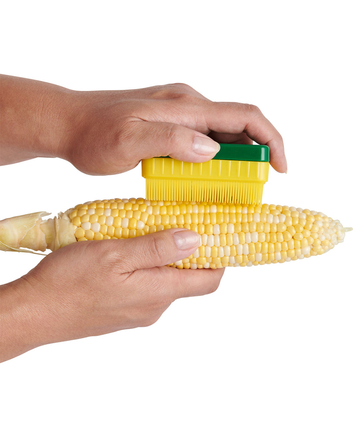 Corn shucker being used on a cob of corn with a white background