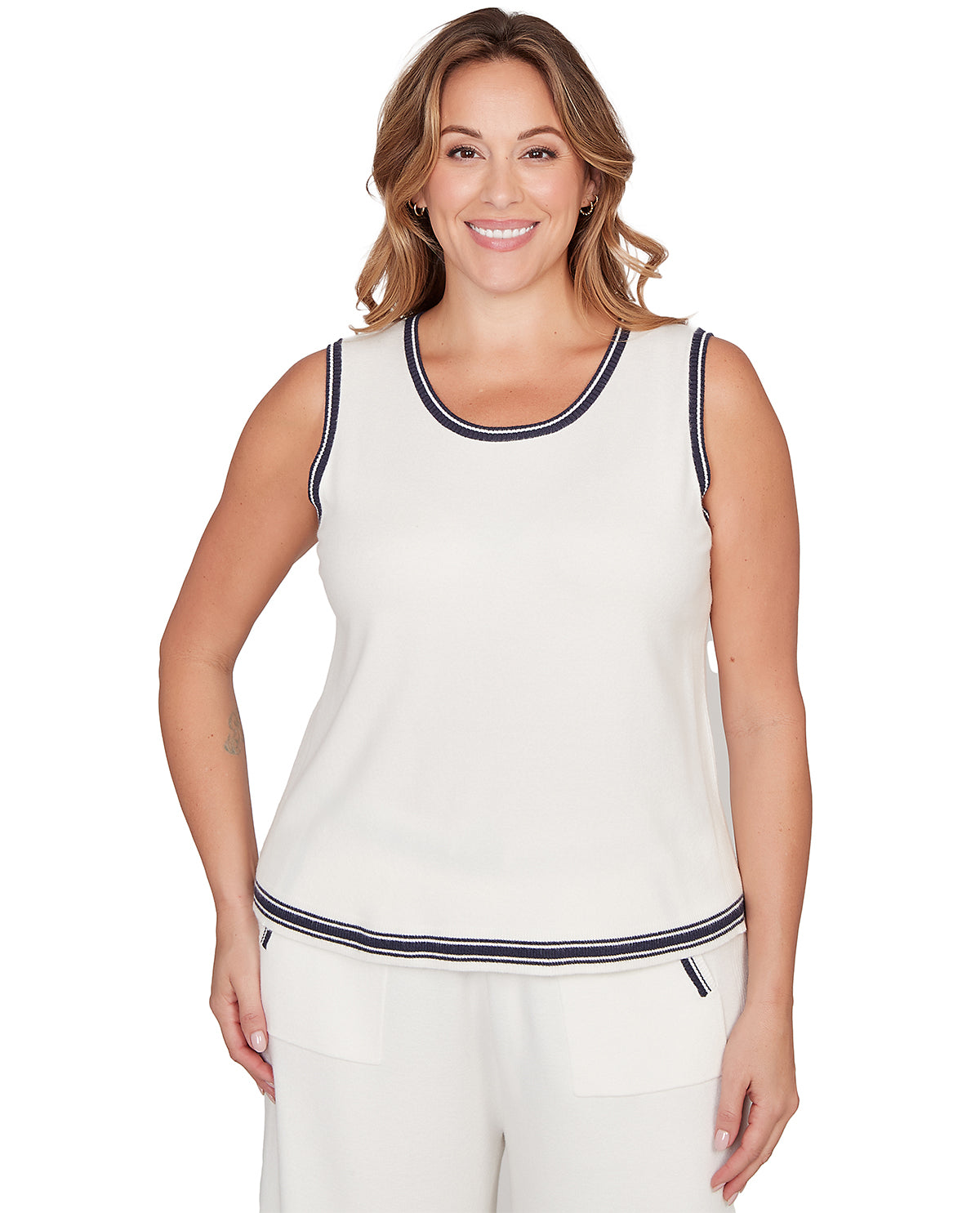 Woman wearing a white sleeveless top with navy trim on a white background