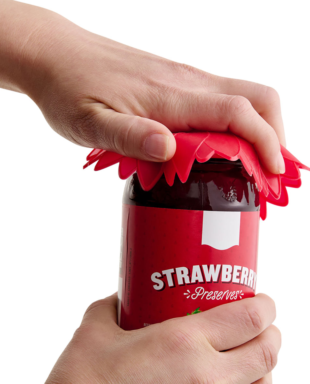 Hand using a red silicone lid to open a jar of strawberry preserves.