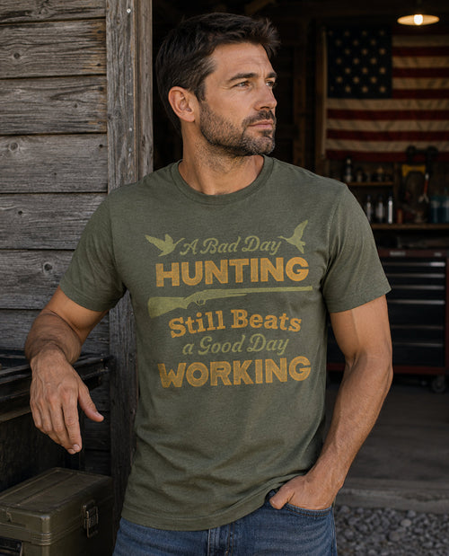 Man wearing a green t-shirt with hunting-themed text, standing in front of a wooden building.