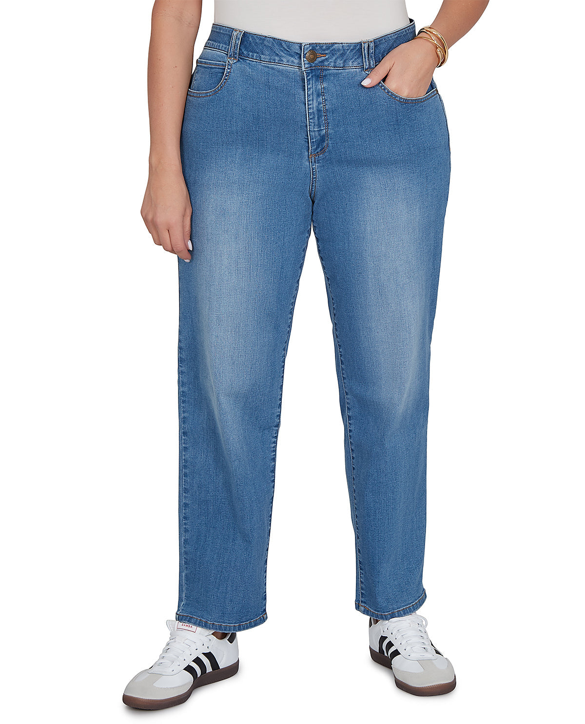 Person wearing blue jeans and white sneakers on a white background