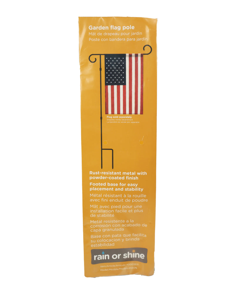A tall, narrow orange packaging sleeve for a garden flag pole. The sleeve features a printed illustration of a black metal flag pole with an American flag and text describing the rust-resistant metal finish and footed base.