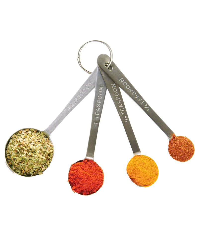Three measuring spoons with spices on a white background