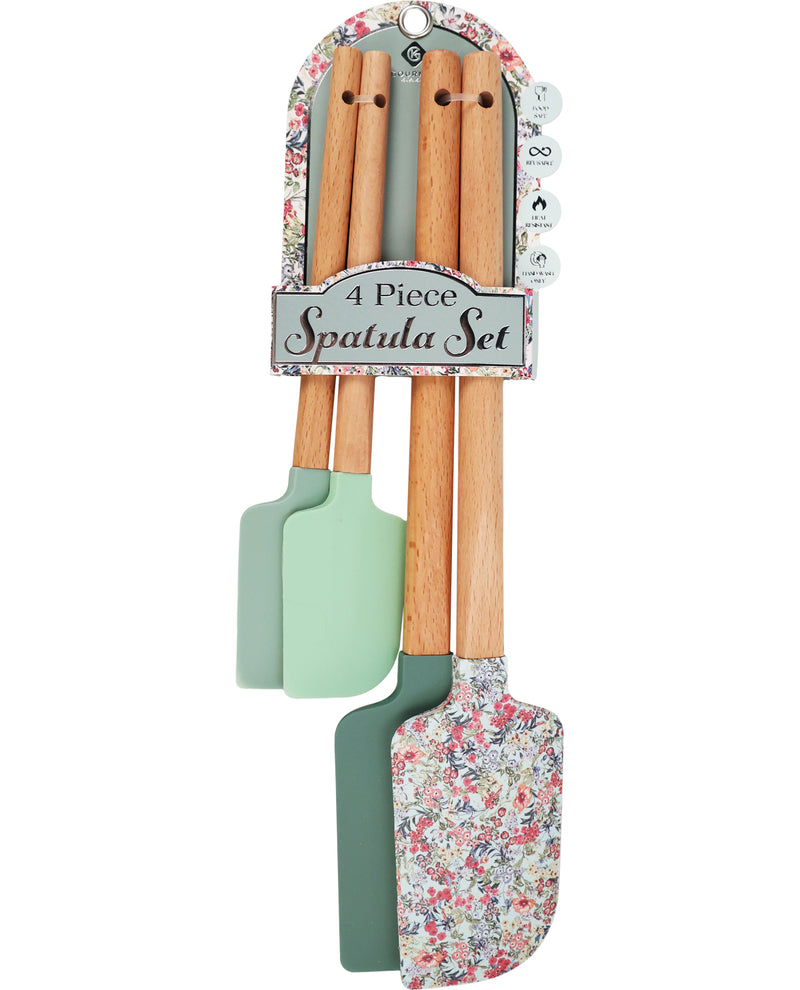 A 4-piece spatula set hanging from a decorative retail hanger. The set includes three wooden-handled spatulas with mint green silicone heads and one wooden-handled spatula with a multicolor floral print silicone head.