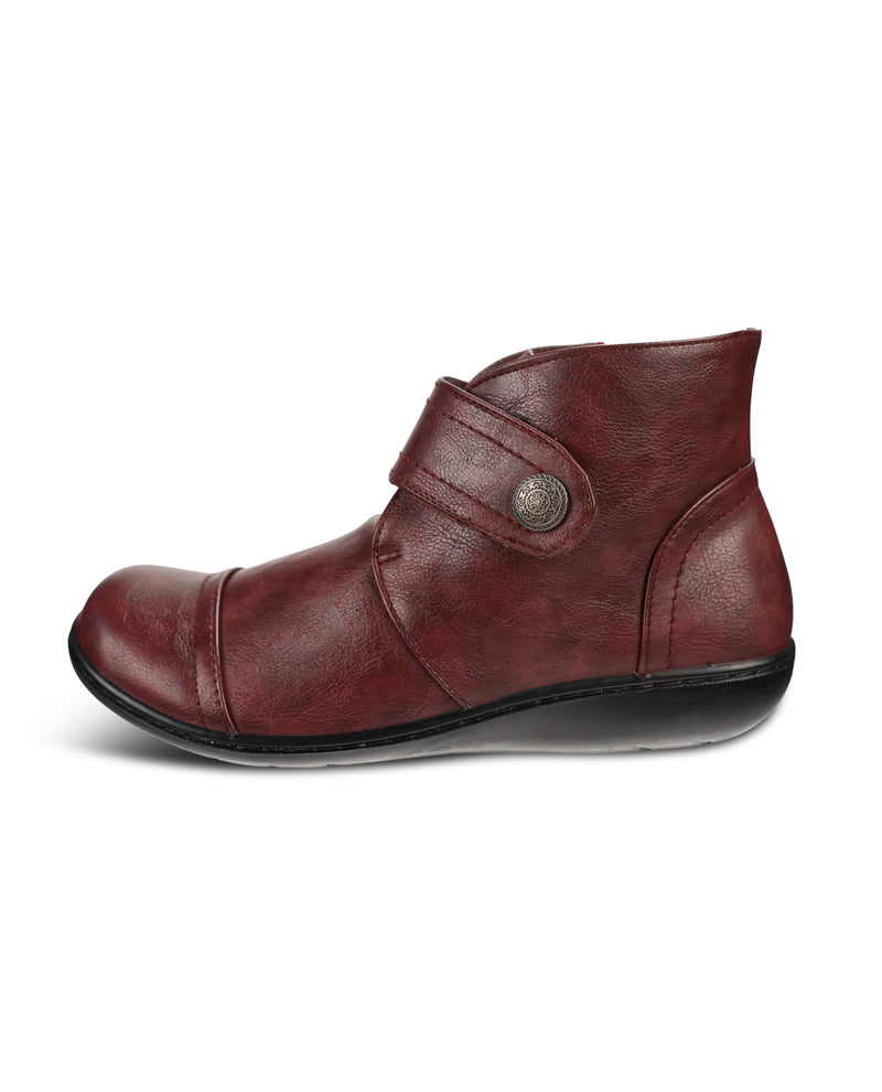 A single dark red leather ankle boot with a strap closure and a decorative metal button, shown from a side profile on a white background.