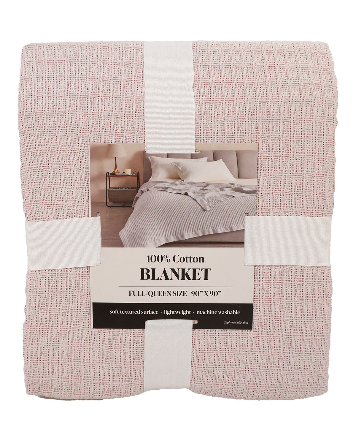 A folded light pink textured cotton blanket wrapped in white paper bands with a central product label, shown on a plain white background.