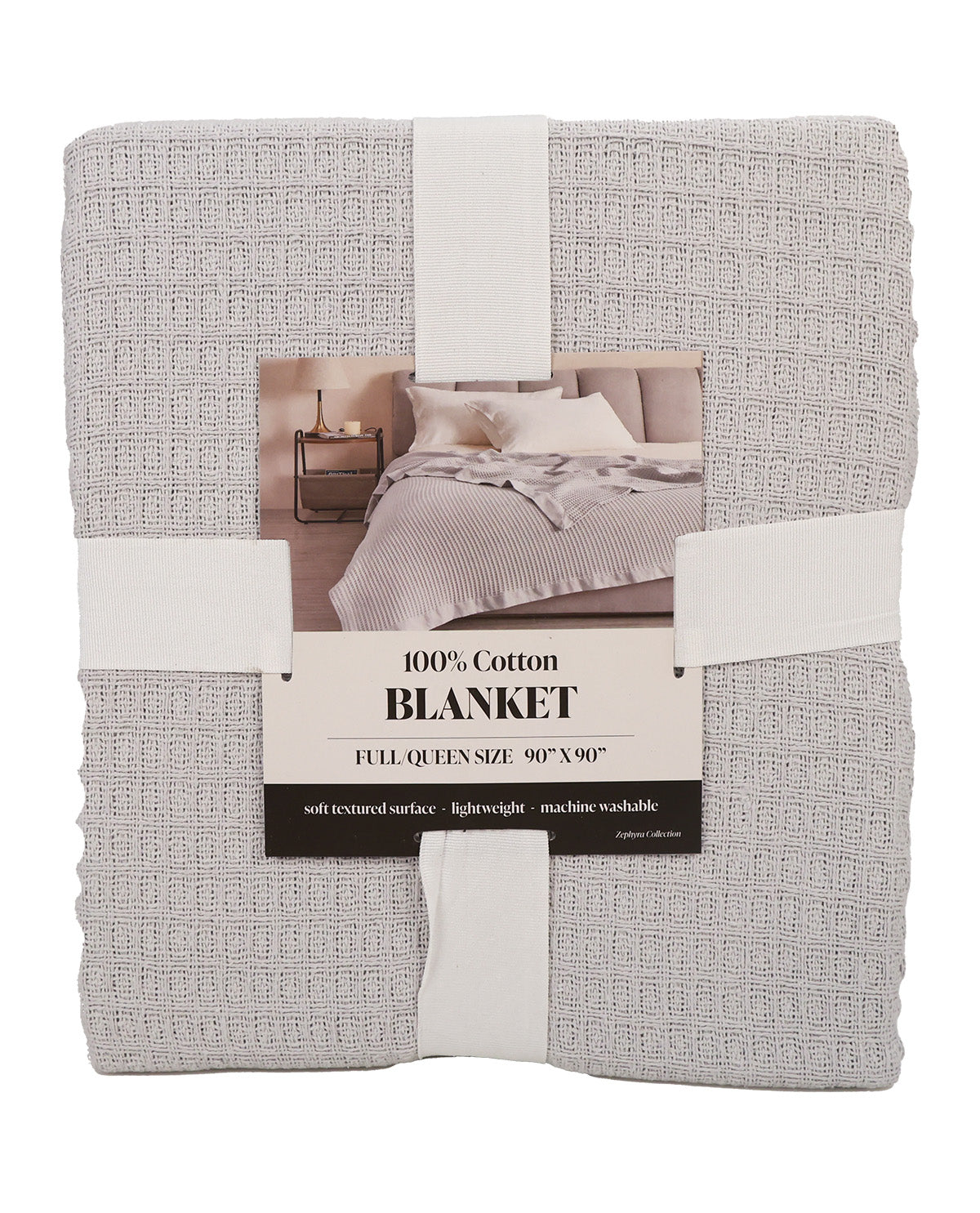 A folded light gray textured cotton blanket wrapped in white paper bands with a central product label, photographed on a plain white background.