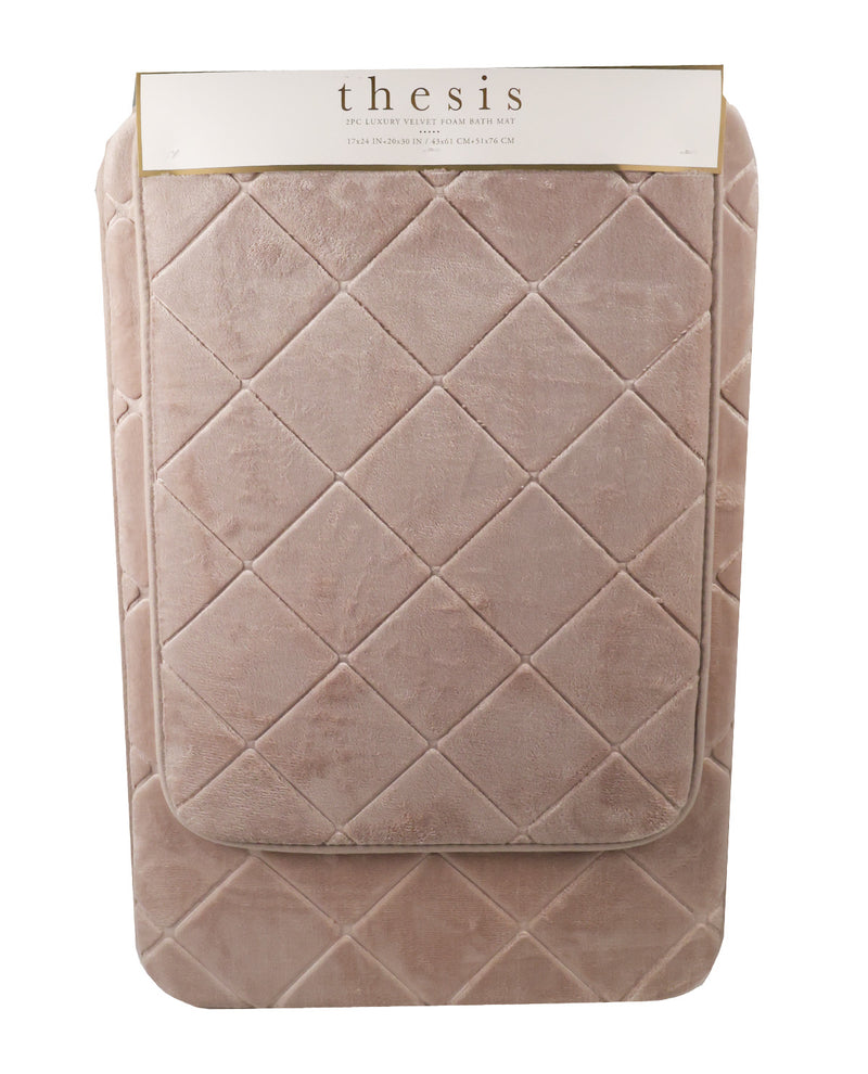 A quilted bath mat in a dusty rose pink velvet fabric, folded with its white paper packaging header card at the top. The header card features the brand name 'thesis' in a serif font.