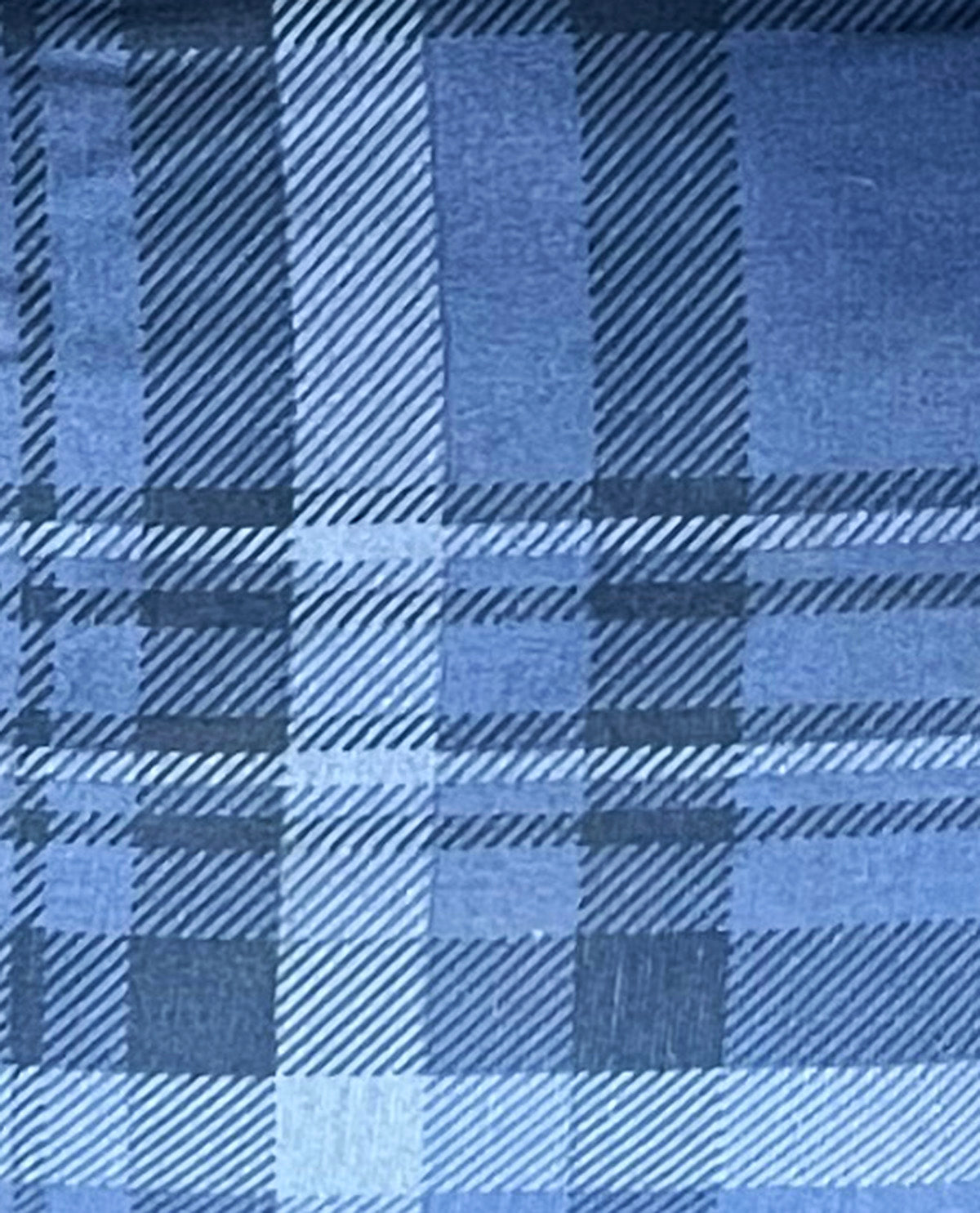 A close-up of a blue plaid fabric pattern with intersecting diagonal stripes in multiple shades of blue.