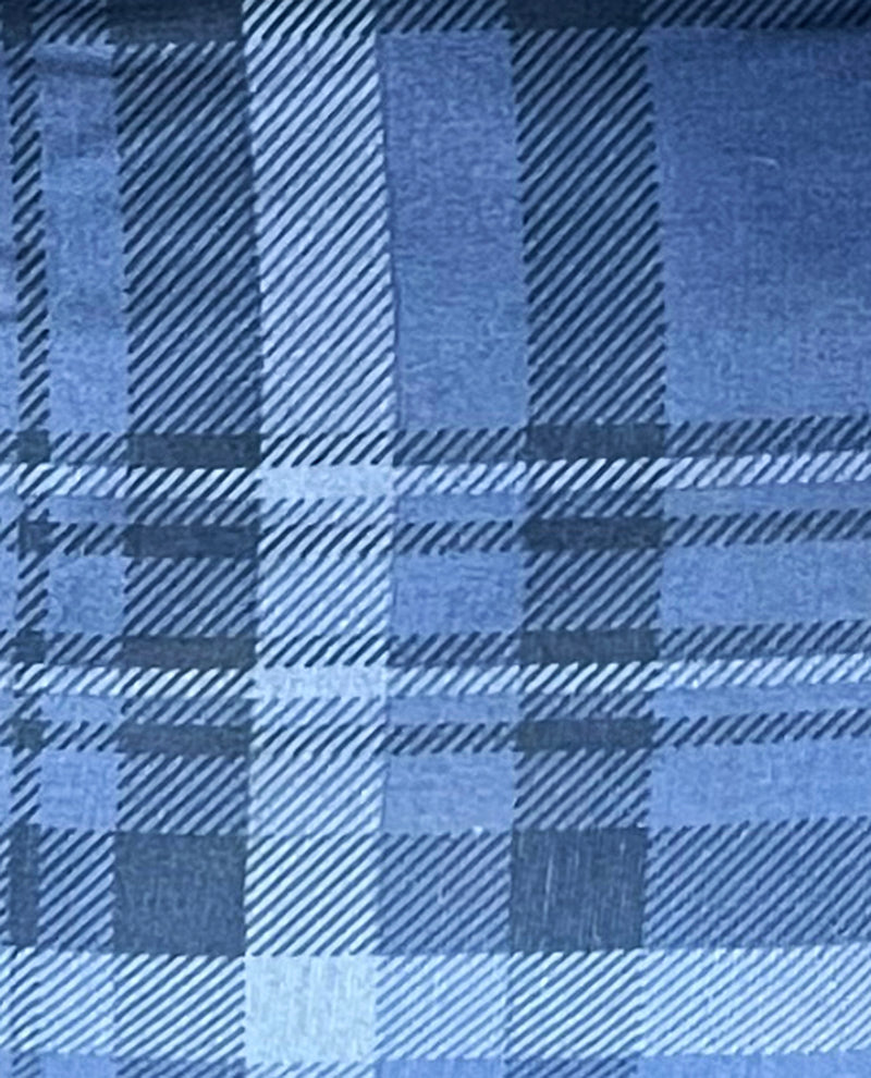 A close-up of a blue plaid fabric pattern with intersecting diagonal stripes in multiple shades of blue.