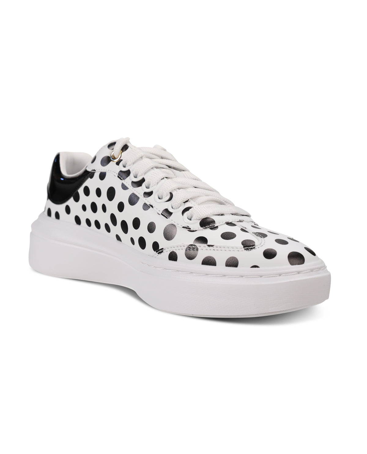 A white low-top platform sneaker with black polka-dot cutout perforations across the upper, white laces, and a thick white sole, shown against a plain white background.