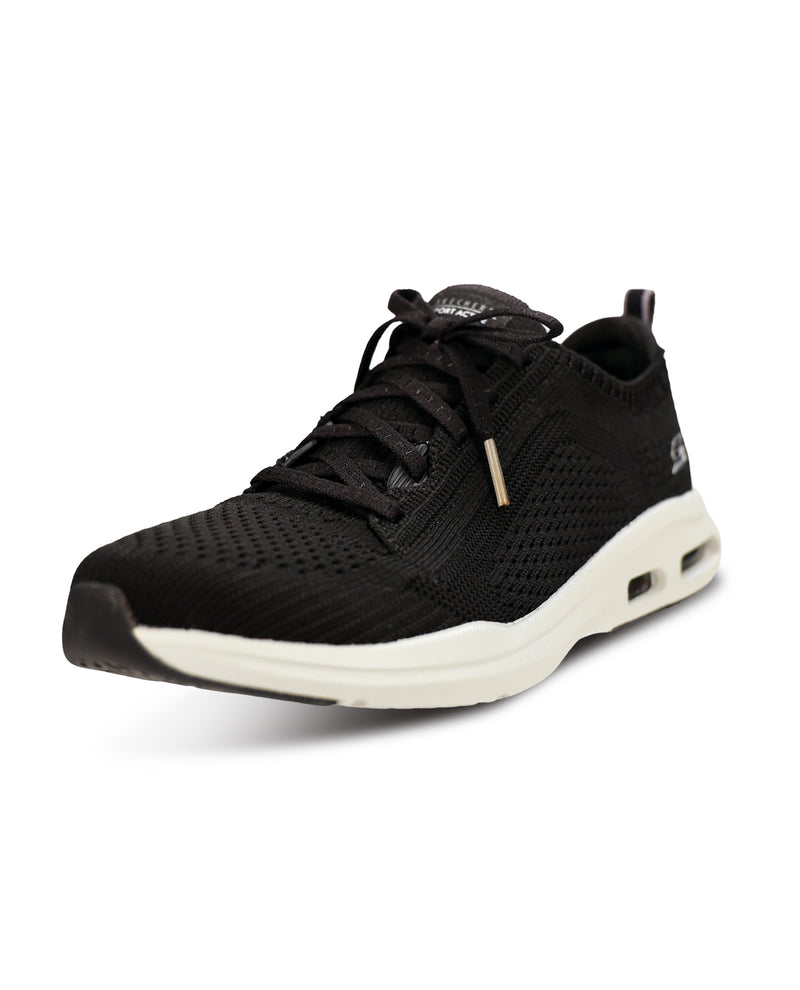 A black knit athletic sneaker with a thick, chunky off-white midsole and a small gold accent near the laces, shown from a three-quarters angle on a white background.