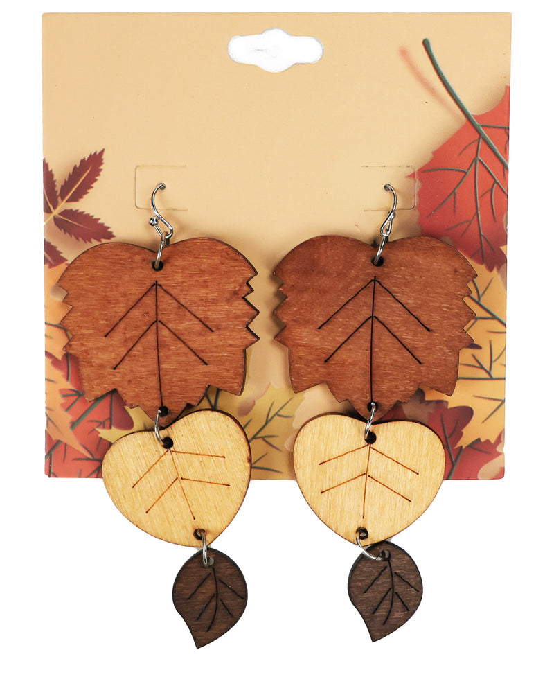 Wooden dangle earrings shaped like autumn leaves, displayed on a printed backing card. Each earring has a medium brown leaf-shaped top piece, a smaller light beige heart-shaped middle piece, and a dark brown leaf-shaped bottom charm.