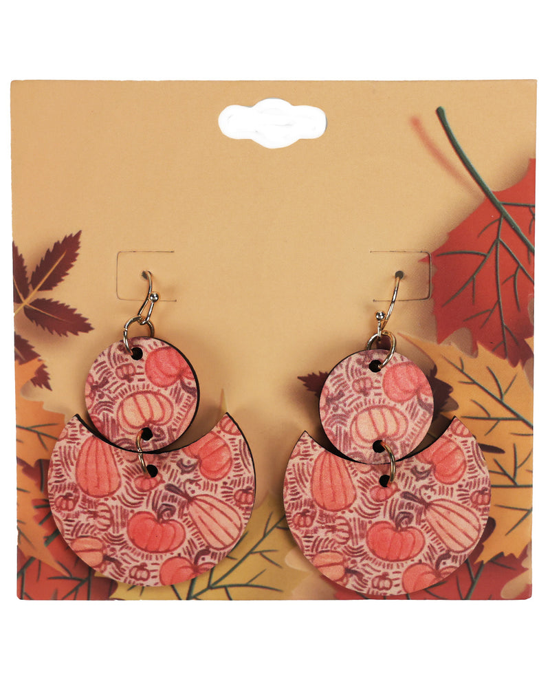A pair of double-tiered dangle earrings with a fall harvest pattern of pumpkins and acorns on a tan background, displayed on a tan retail card with autumn leaf graphics.