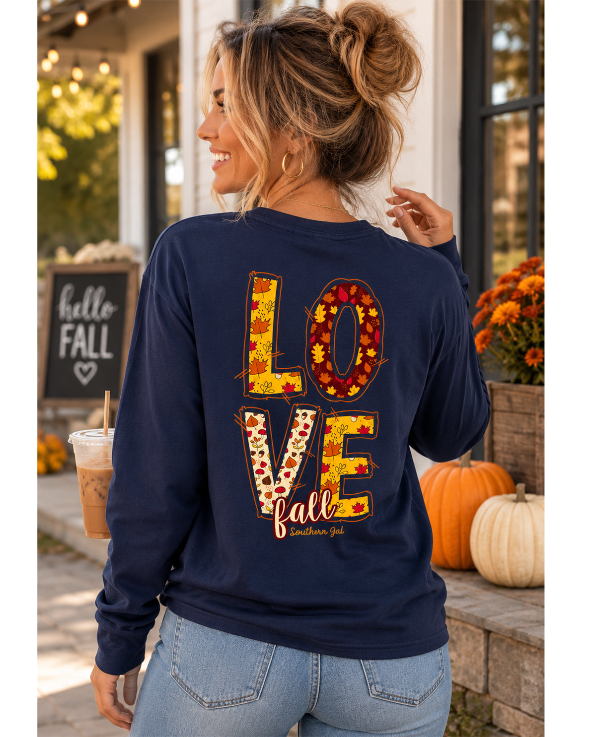 Woman wearing a navy sweatshirt with 'LOVE fall' design outdoors.