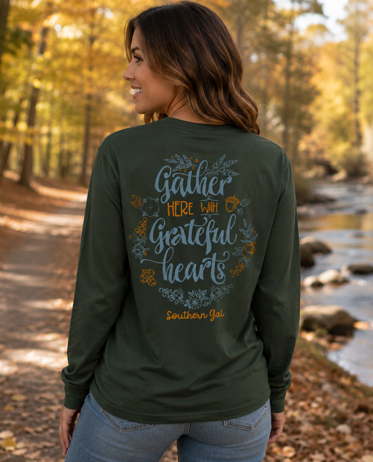 Green long-sleeve shirt with 'Gather Here with Grateful Hearts' text on missy model outside 