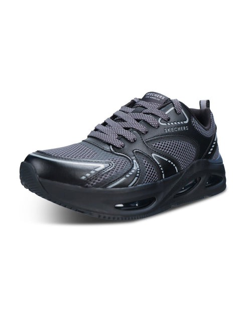 A Skechers athletic sneaker in dark gray and black, featuring a breathable mesh upper, gray laces, and a thick cushioned black sole with visible air cushioning chambers, shown against a plain white background.