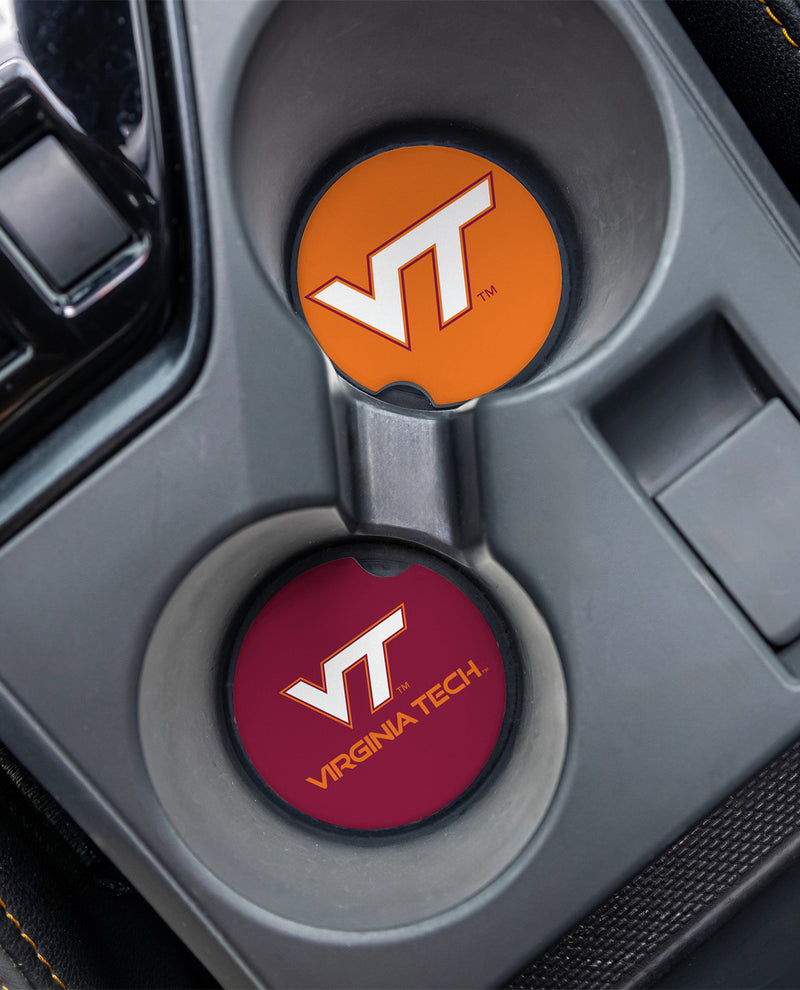 Two round car cup holder coasters featuring the Virginia Tech VT logo, one in orange and one in maroon, set into a gray center console.