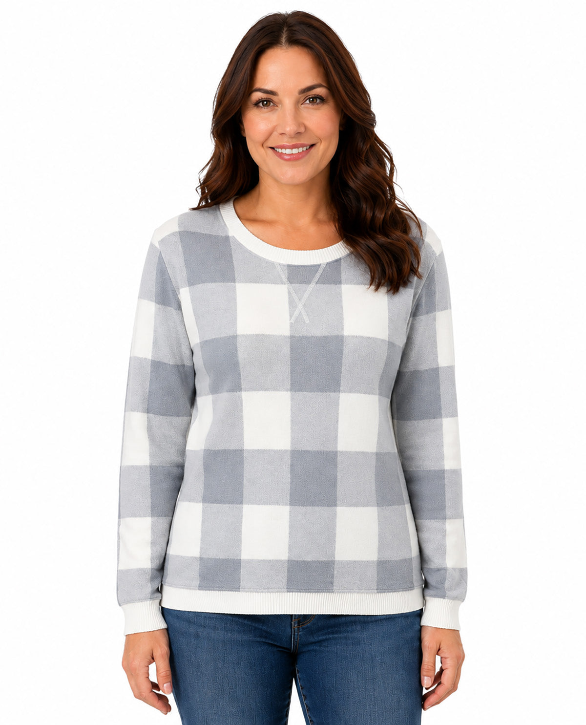 A woman wearing a long-sleeve crewneck sweatshirt with a gray and white buffalo check pattern, paired with blue jeans, against a plain white background.