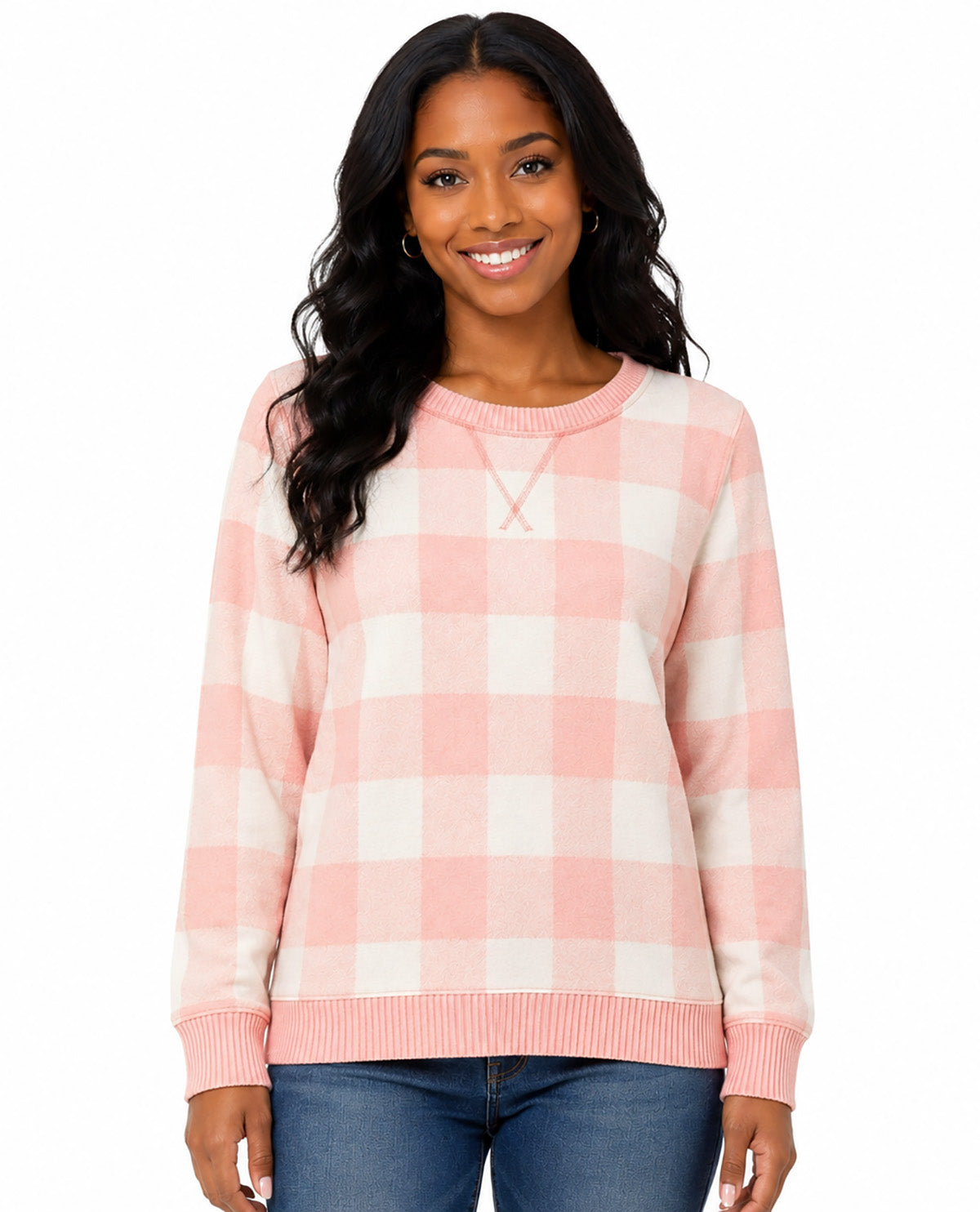 A woman wearing a pink and white gingham check long-sleeve crewneck sweater, paired with blue jeans, against a plain white background.
