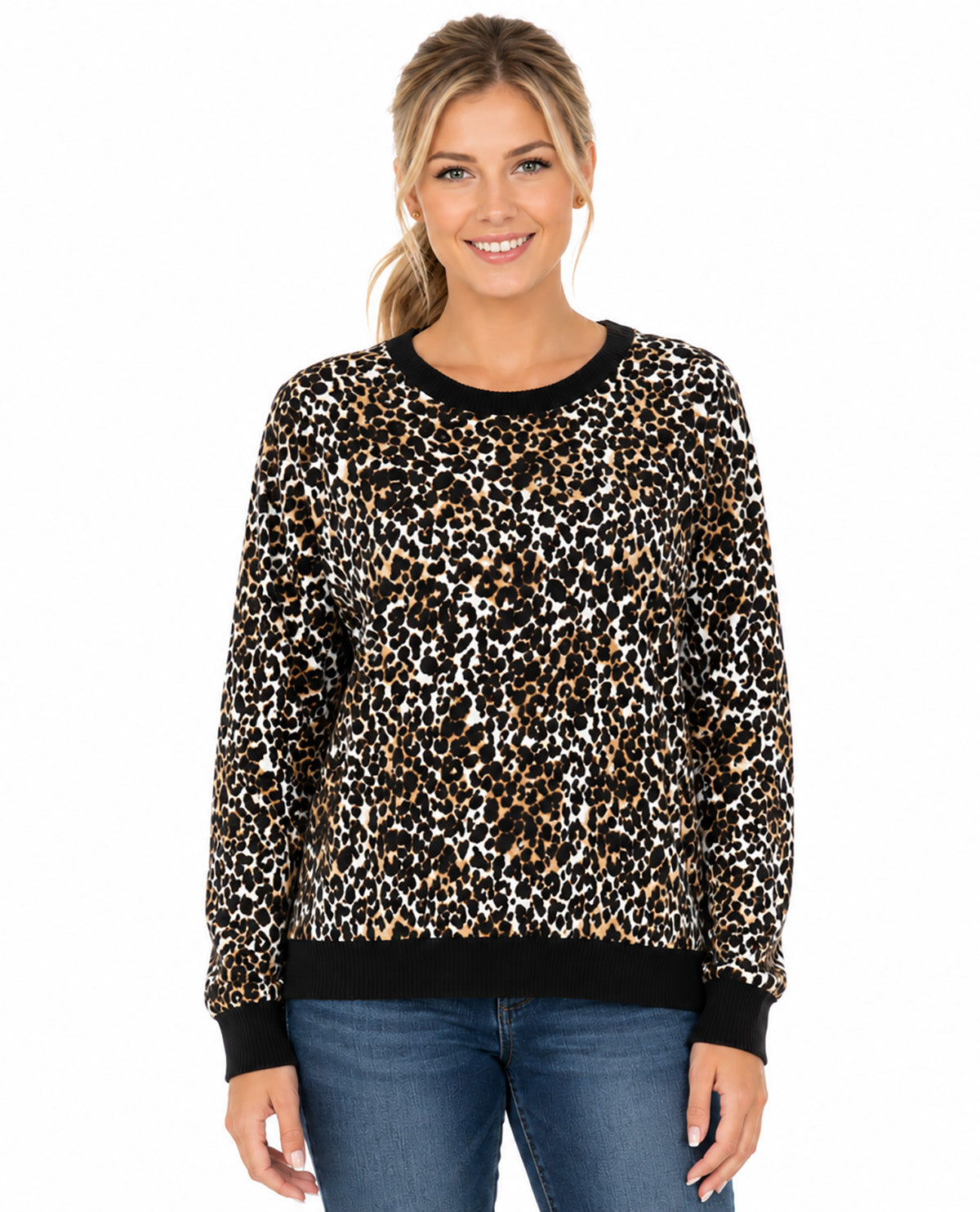 A woman modeling a long-sleeve crewneck sweater with a black, brown, and beige leopard print pattern and solid black ribbed collar, cuffs, and hem, paired with blue jeans against a plain white background.