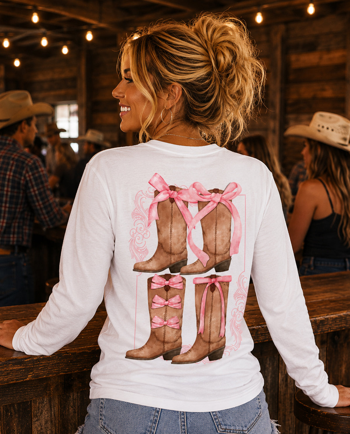 Woman wearing a white long-sleeve shirt with pink boots and bows design in a rustic setting.