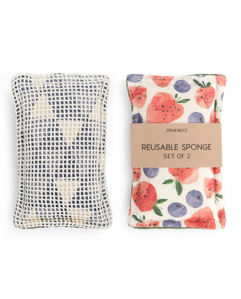 Two reusable sponge cleaning tools from Demaco on a white background. One sponge has a white and gray woven pattern, and the other has a cream background with a red, purple, and green watermelon and berry print, wrapped in a kraft paper band labeled 'REUSABLE SPONGE SET OF 2'.