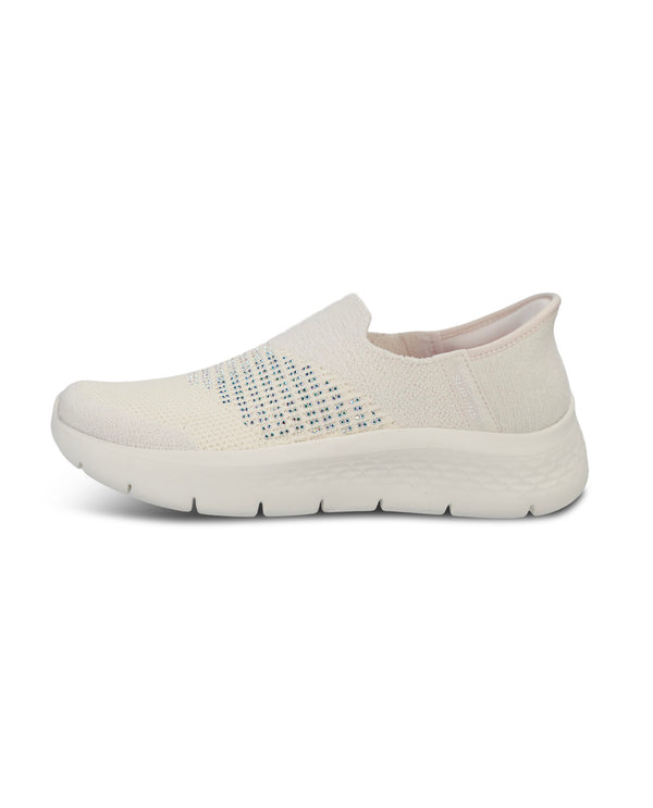 A single slip-on sneaker in off-white, featuring a textured knit upper with a pattern of small blue and black dots on the side, a thick cushioned sole, and a low-profile rounded toe, shown against a plain white background.