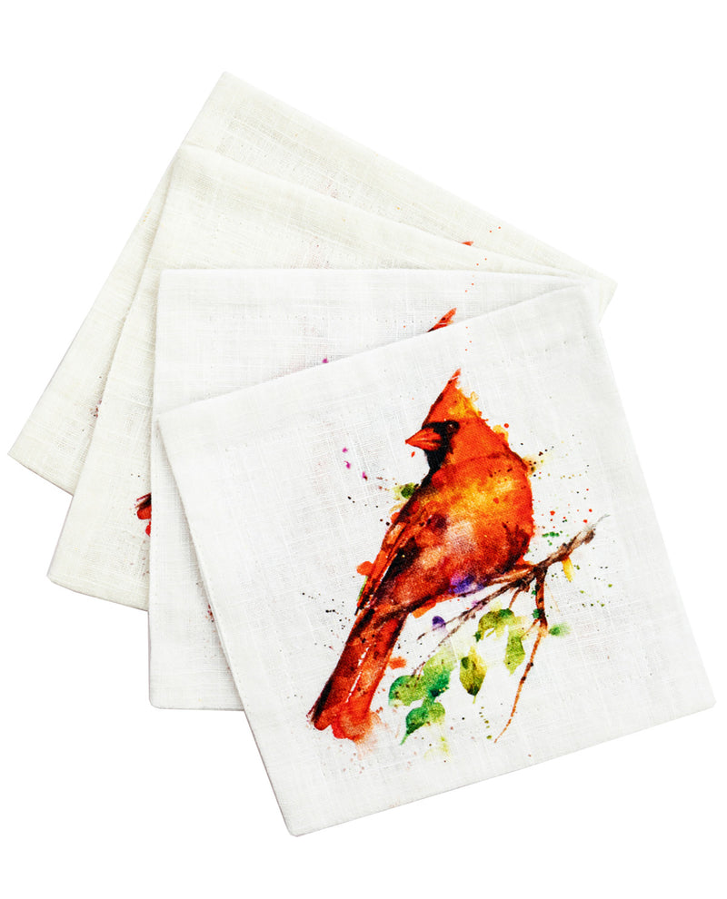 Three square white napkins stacked slightly offset, featuring a watercolor-style print of a red cardinal bird on a branch with green leaves on the front napkin.