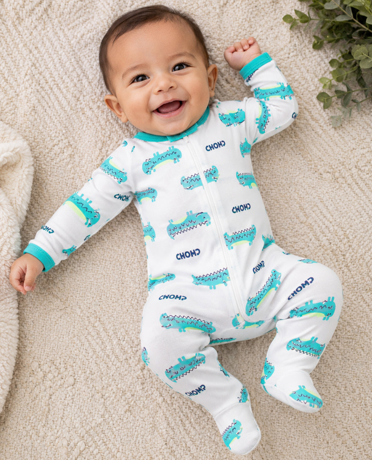 Baby boy wearing long sleeve coveralls with alligator print