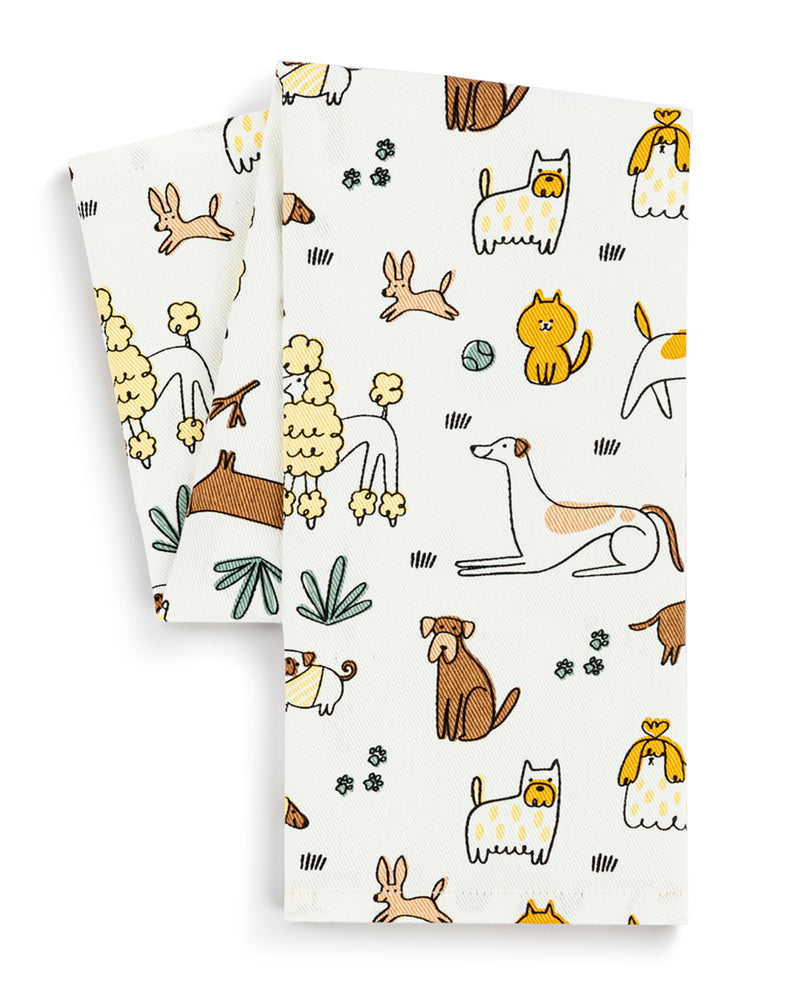 Two white tea towels with a whimsical pattern of illustrated dogs, cats, rabbits, and flowers, displayed on a clean white background.