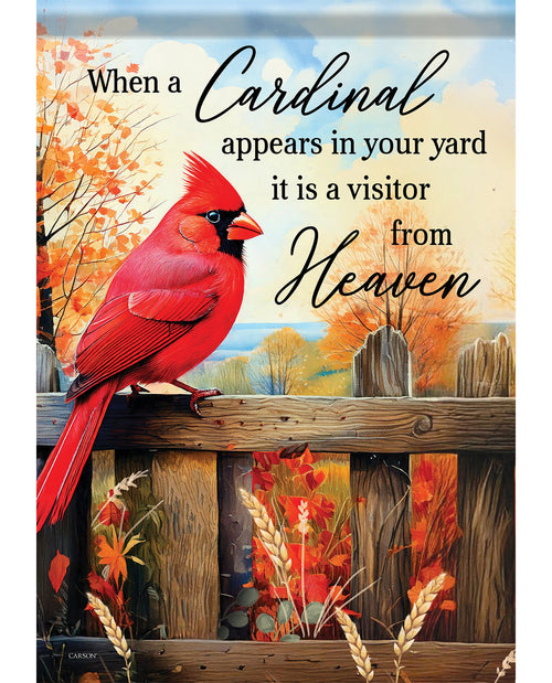 A decorative sign or print featuring a bright red cardinal perched on a wooden fence, with autumn trees in the background and the text, 'When a Cardinal appears in your yard it is a visitor from Heaven.'.