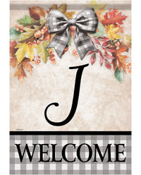 A fall-themed welcome garden flag featuring a large black script letter 'J' on a beige background, surrounded by colorful autumn leaves, acorns, and a gray-and-white gingham bow. The bottom section has a black and gray gingham border with the word 'WELCOME' in bold black letters.