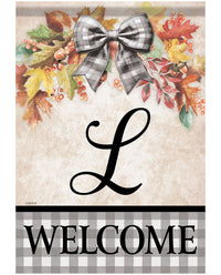 A decorative autumn-themed welcome sign with a large black script letter L in the center, a gray-and-white gingham bow at the top, colorful fall leaves and berries around it, and the word WELCOME in black letters on a gray-and-white gingham band at the bottom.