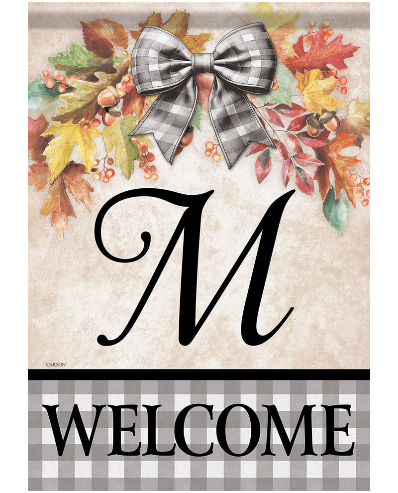 A personalized fall-themed welcome garden flag with a beige textured background, a large black script letter 'M', an autumn leaf and berry wreath with a gray-and-white gingham bow, and a bottom banner reading 'WELCOME' in black text on a gray gingham background.