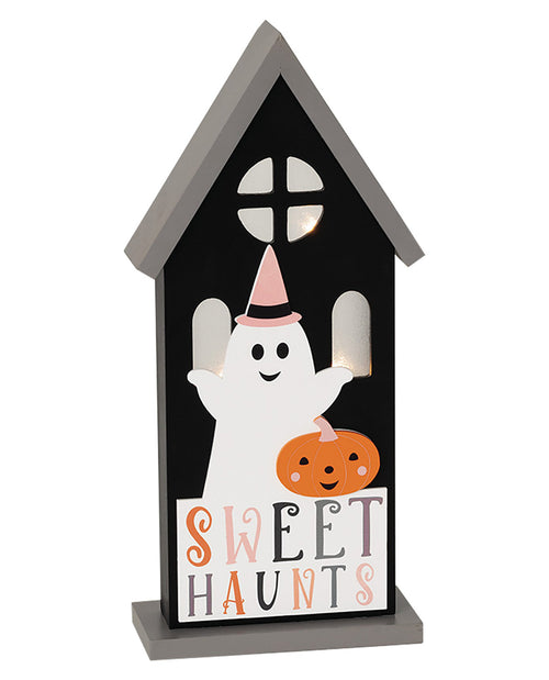 A house-shaped Halloween decorative sign with a black front panel, gray roof and base, a white ghost wearing a pink hat, an orange jack-o'-lantern, and the words 'SWEET HAUNTS' on a white background.