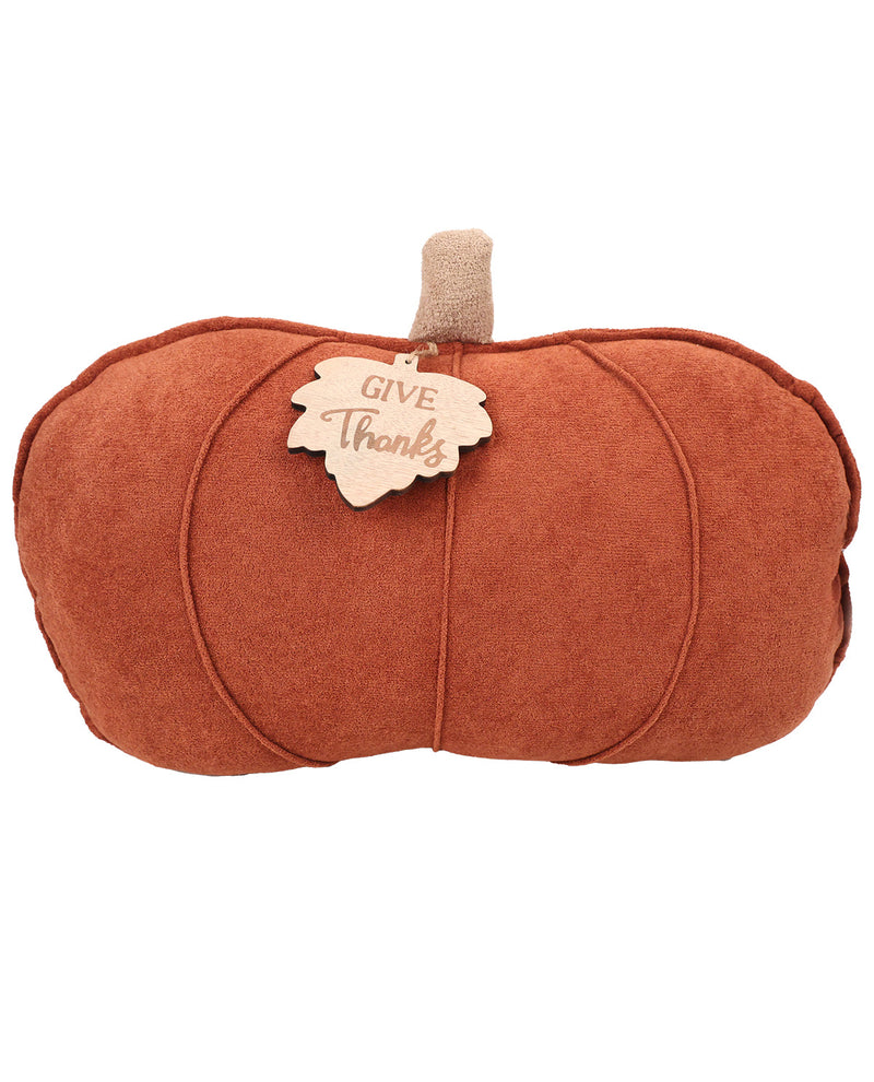 An orange-brown faux suede pumpkin-shaped decorative pillow with a beige stem and a hanging wooden tag that reads 'GIVE THANKS', shown on a plain white background.