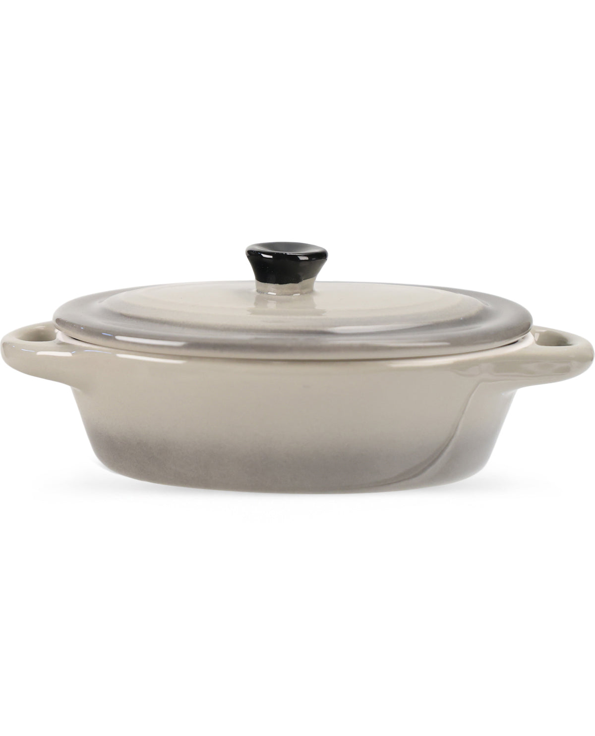 A ceramic oval casserole dish with a matching lid, featuring a smooth gradient from warm beige at the top to gray at the bottom, with a small black knob on the lid.