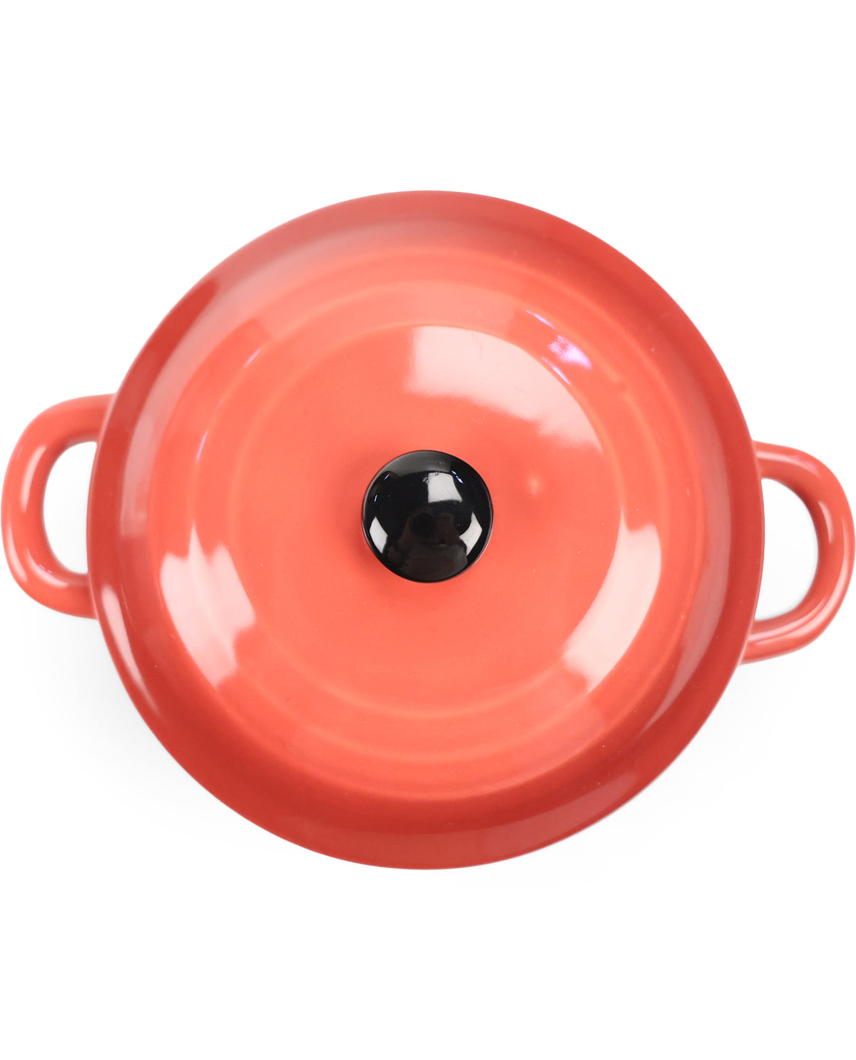 A top-down view of a round, glossy orange-red enamel pot or casserole dish with two side handles and a black knob on the lid, set against a plain white background.