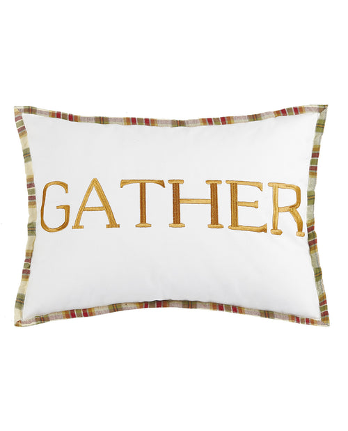 A square white decorative pillow featuring the word 'GATHER' in large gold embroidered letters, finished with a multicolor plaid border.