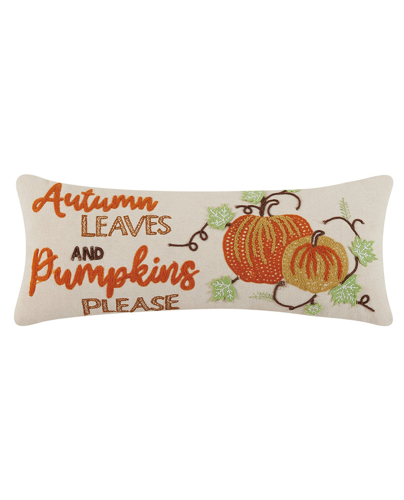 A rectangular cream throw pillow featuring embroidered autumn text that reads 'Autumn Leaves and Pumpkins Please' alongside two orange pumpkins and green leaves.