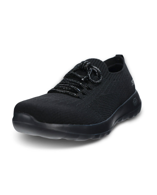 A black knit slip-on sneaker with textured laces and a thick black sole, shown from a three-quarters angle on a white background.