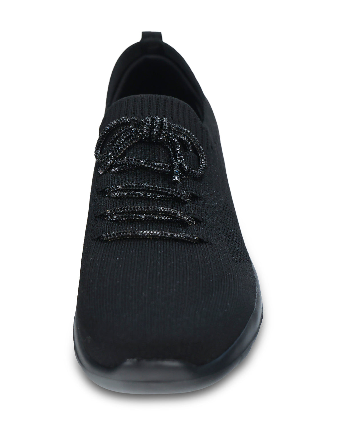 A black knit slip-on sneaker with textured laces and a thick black sole, shown from a three-quarters angle on a white background.