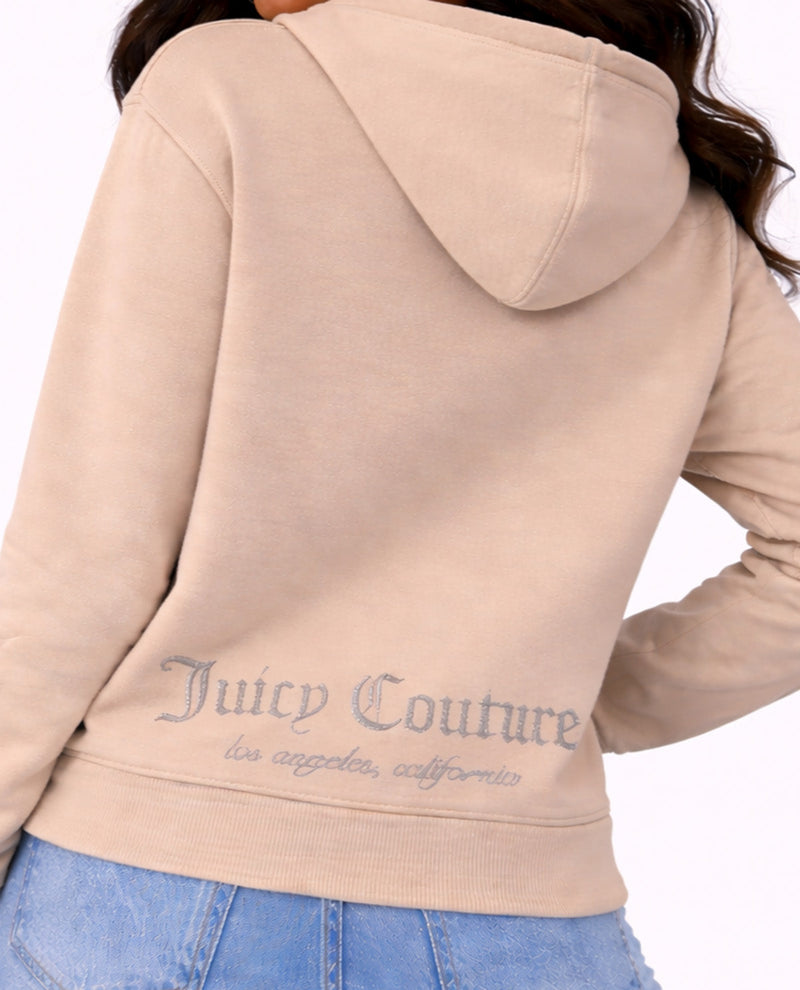Beige hoodie with 'Juicy Couture' branding on the back, worn by a person.