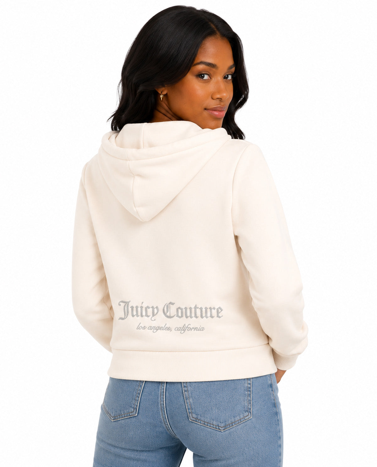A woman shown from the back wearing a cream-colored Juicy Couture hoodie and light blue jeans against a plain white background.