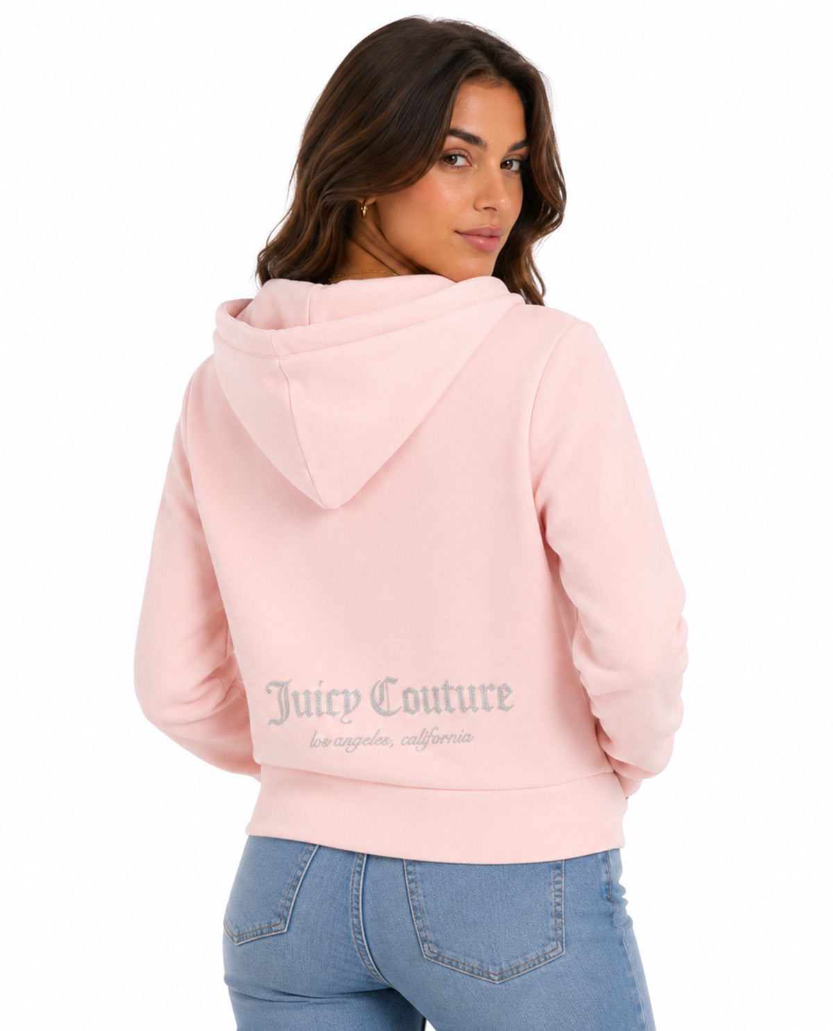 A woman wearing a light pink Juicy Couture cropped hoodie, shown from the back. The hoodie features the Juicy Couture logo printed in gray across the lower back.