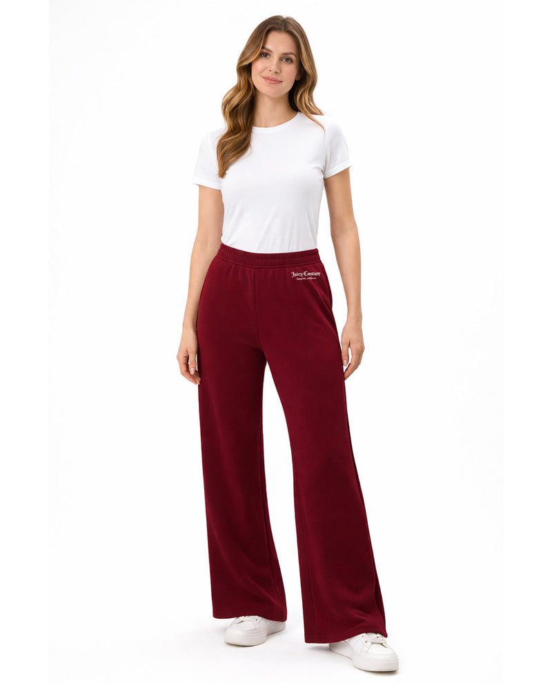 Woman wearing maroon pants with a visible brand logo on a white background